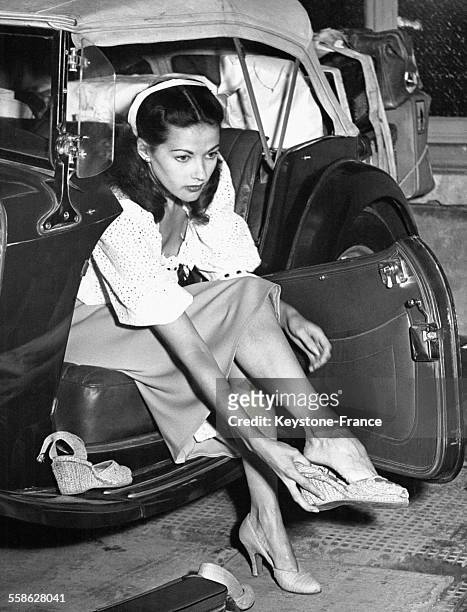 Jeune femme, assise dans sa voiture, changeant de chaussures.
