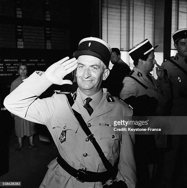 L'aeroport d'Orly ou ont debarque les acteurs du film 'Les gendarmes a Saint-Tropez', Louis de Funes en uniforme de gendarme salue le photographe, le...