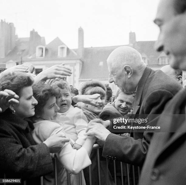 De passage en Mayenne, le general Charles de Gaulle console un petit garcon qui pleure le 23 mai 1965 en Mayenne, France.