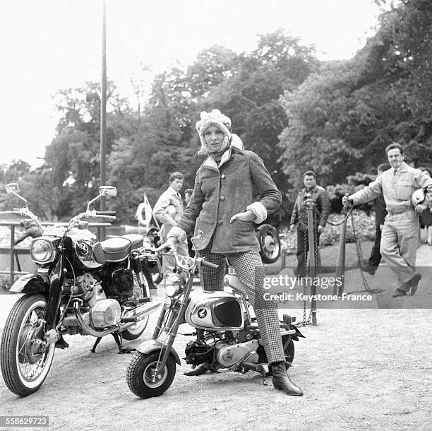 Jeune fille presentant 'Puch', veste-caban en agneau velours marron double et casque en mouton le 24 mai 1965 au chalet des îles dans le Bois de...