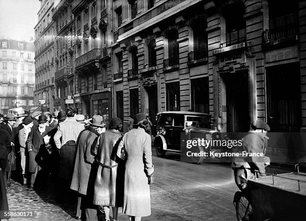 La foule de curieux stationnant devant l'immeuble ou se trouve la Compagnie d'assurances 'La Confiance' pendant la perquisition, le 5 janvier 1934 a...