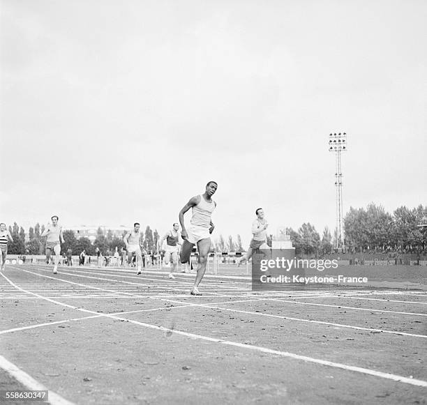 Arrivee de Roger Bambuck sur la course du 200 mètres lors des championnats d'athletisme scolaires et universitaires en juin 1965 au stade Charlety, à...