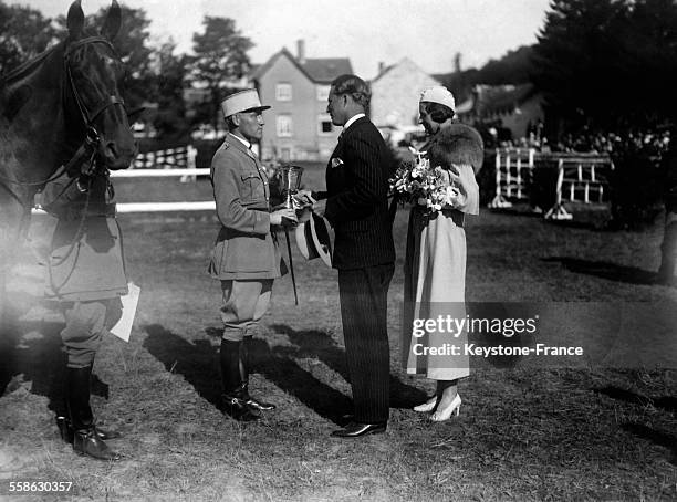 Le Roi Leopold III et la Reine Astrid felicitent un officier francais concurrent d'une epreuve hippique, circa 1934 en Belgique.