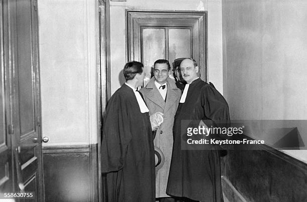 Gilbert Romagnino, l'homme de confiance de Stavisky, sortant du bureau du juge d'instruction accompagne de son avocat Raymond Hubert, a Paris,...