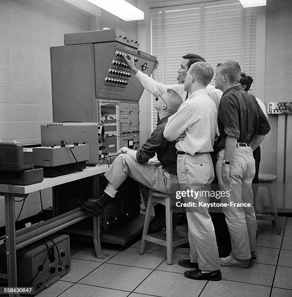 Un professeur dispense son cours aux etudiants devant une machine avec des commandes electroniques en juin 1965, à l'universite de Princeton, New...