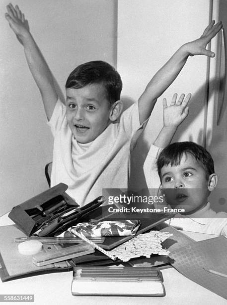 Petits garçons enthousiasmés par leurs nouvelles fournitures scolraires, en France, le 14 septembre 1964.