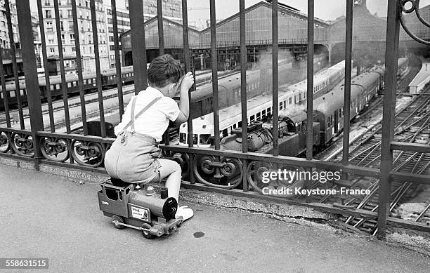 Pierre, petit garçon impatient de partir en vacances, est arrivé tôt à la Gare du Maine pour attendre l'entrée du train le 30 juin 1965 à Paris,...