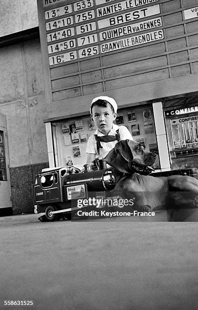 Pierre, petit garçon impatient de partir en vacances, est arrivé tôt à la Gare du Maine avec son chien pour attendre l'entrée en gare du train le 30...