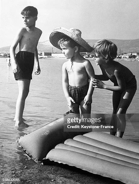 Un groupe de jeunes enfants à la mer pendant les vacances le 8 juillet 1965.