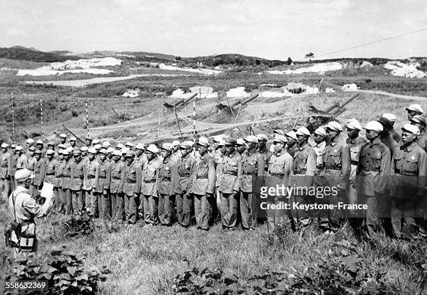 Membres de l'unité d'artillerie de l'armée des volontaires du peuple chinois écoutant leur commandant leur lire les ordres d'armistice signés par le...