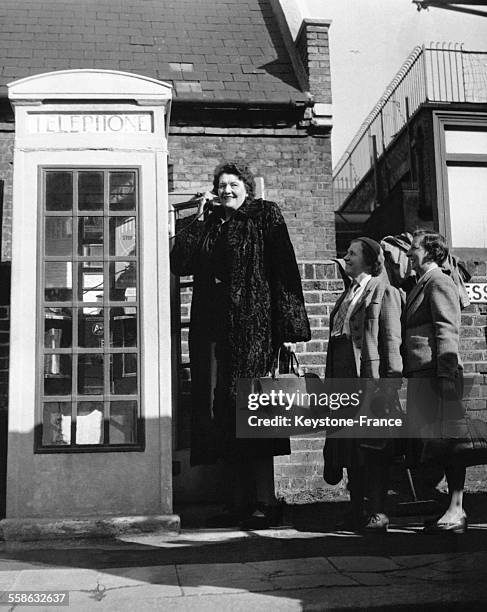 La plus grande femme du monde, Katja Van Dyck, est obligee de telephoner depuis l'exterieur de la cabine telephonique parce que l'interieur de...