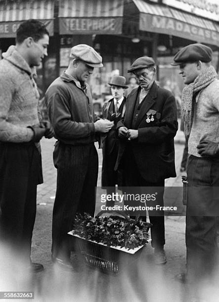 Le boxeur Marcel Thil achète un brin de muguet à un ancien combattant pour lui porter bonheur pour son match de championnat du monde le 1er mai 1934...