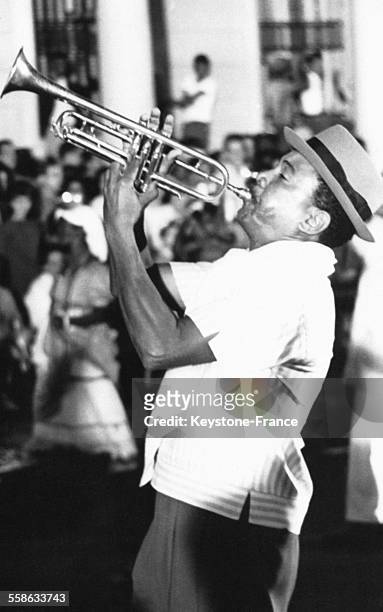 Cet ouvrier, vêtu chichement, extirpe de sa trompette, à la force de ses poumons, des mélodies que la foule reprend, à La Havane, Cuba.