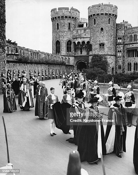 Procession de l Ordre de la Jarretiere a Windsor, avec les Ducs de Gloucester et de Kent, suivis par la Reine Mary, sa traine tenue par Alexander...