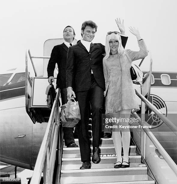 Johnny Hallyday and Sylvie Vartan at the gangway of the plane waving to the crowd at Olry airport, France, on February 27, 1967.