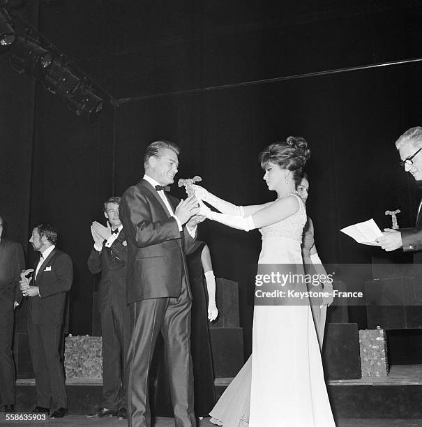 Gina Lollobridgida remettant une 'Victoire' à Jean Marais lors de la cérémonie des vingtièmes 'Nuits du cinéma', à Paris, France, le 29 octobre 1965.