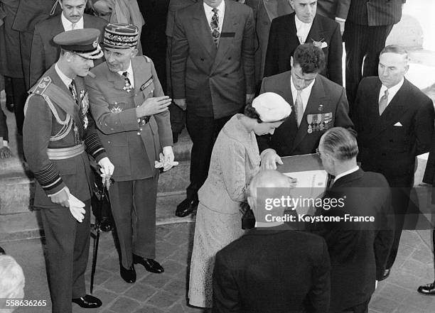 La reine Elizabeth II, accompagnée de son mari Philip Mountbatten, duc d'Edimbourg, signe le registre à l'Arc de Triomphe à Paris, France en avril...