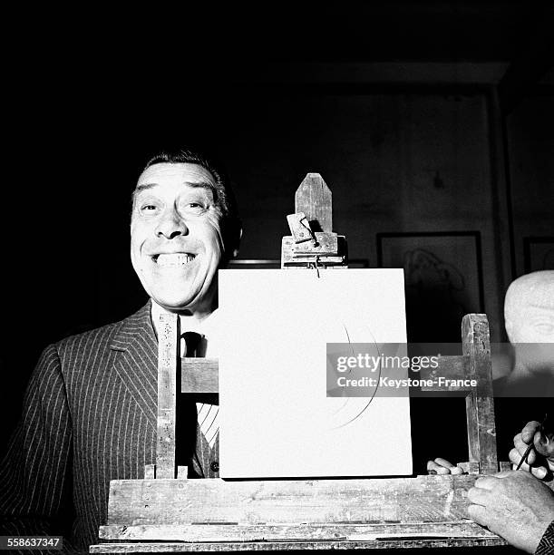 Fernandel posant à côté d'un plâtre à son effigie fait par le sculpteur Lucien Gibert, en France, le 16 novembre 1965.