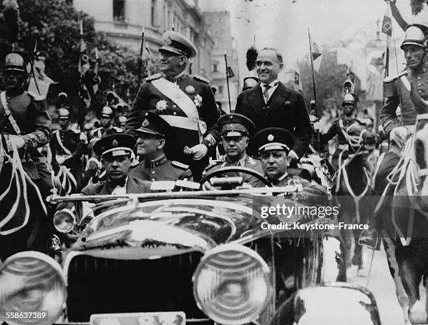 Le general Agustin Pedro Justo, president de la Republique argentine, et Getulio Vargas, president du Bresil, debout dans une voiture presidentielle...