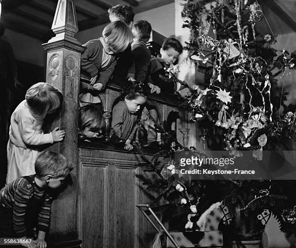 Orphelins celebrant Noel autour d'un sapin dans un des orphelinats du Dr Barnardo, a Haslemere, Royaume-Uni.