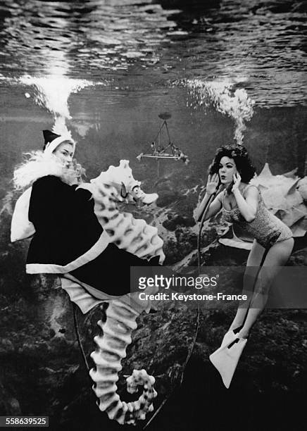 Spectacle de danse aquatique mettant en scene un Pere Noel chevauchant un immense hippocampe, a Miami, Floride, le 24 decembre 1962.