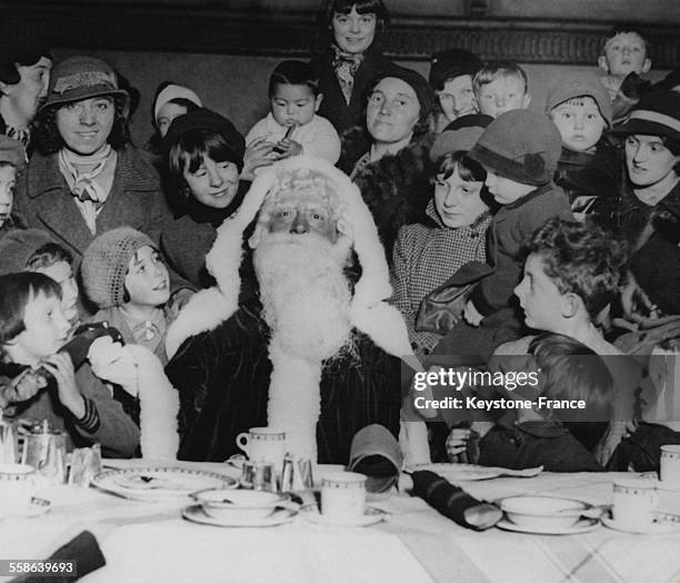 Pere Noel entoure d'enfants dans une ecole, a Londres, Royaume-Uni.