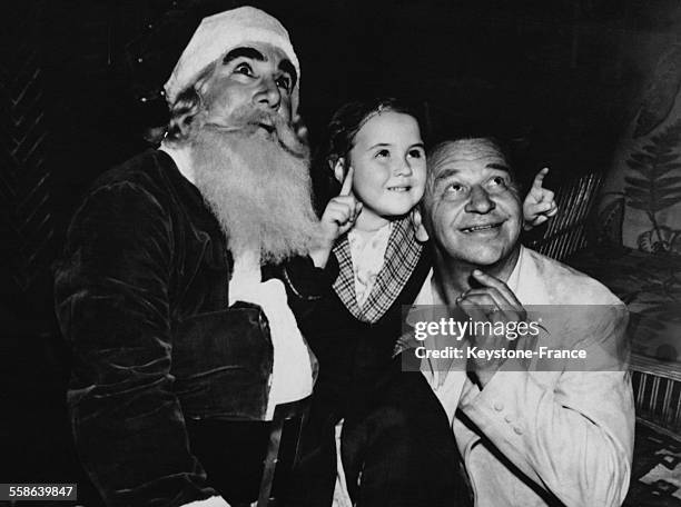 Acteur Sydney Jarvis deguise en Pere Noel accompagne de l'acteur Wallace Beery et de sa fille, Carol Ann Beery, a l'occasion d'une soiree au profit...