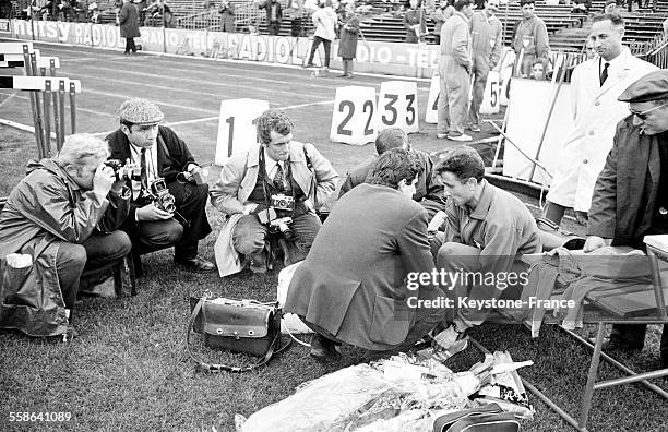 Athlète français Michel Jazy, entouré de photographes et de journalistes, vainqueur du 5000 mètres lors de la rencontre d'athlétisme...