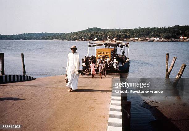 Un prêtre arrive à Panjim par le bateau reliant la ville de Betim à celle de Panjim par la traversée du fleuve Mandovi, Goa, Inde, années 70.