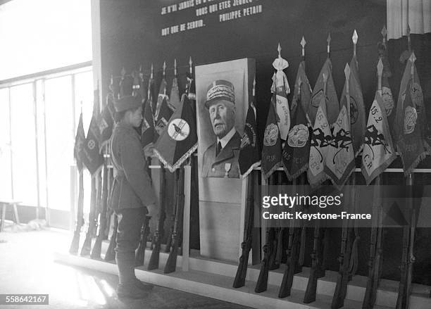Encadrant le portrait du Maréchal Pétain, quelques fanions de glorieux régiments sont présentés dans l'exposition de l'Armée nouvelle organisée dans...