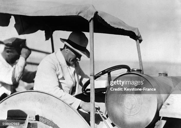 Mustafa Kemal Ataturk dans sa ferme conduisant une machine agricole en Turquie le 23 juillet 1929.