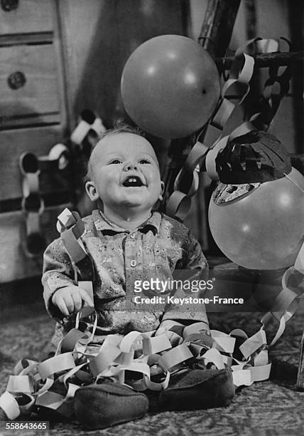 Bebe suit d'un regard brillant d'envie le ballon qui s'envole, riant aux eclats et decouvre deux petites dents blanches, le 15 decembre 1939.