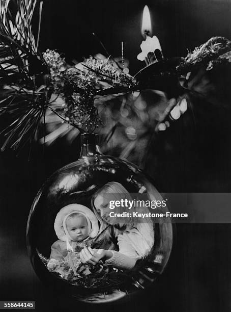 Mere et enfant se refletant dans une boule du sapin de Noel en Republique Tcheque.