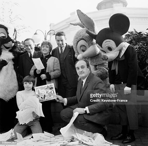 René Goscinny, Mick Micheyl, Roland Dhordhain, Pierre Tchernia et des personnages de Walt Disney entourent Eric Damain au milieu des dessins du...