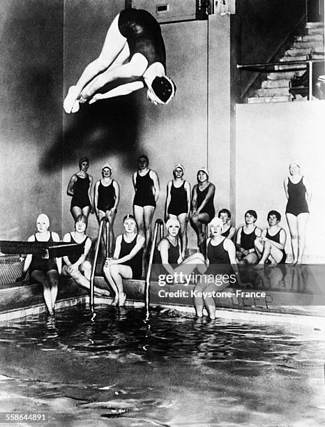 Femme effectuant un plongeon dans la piscine du pavillon athlétique feminin, à Washington, DC, le 26 février 1930.