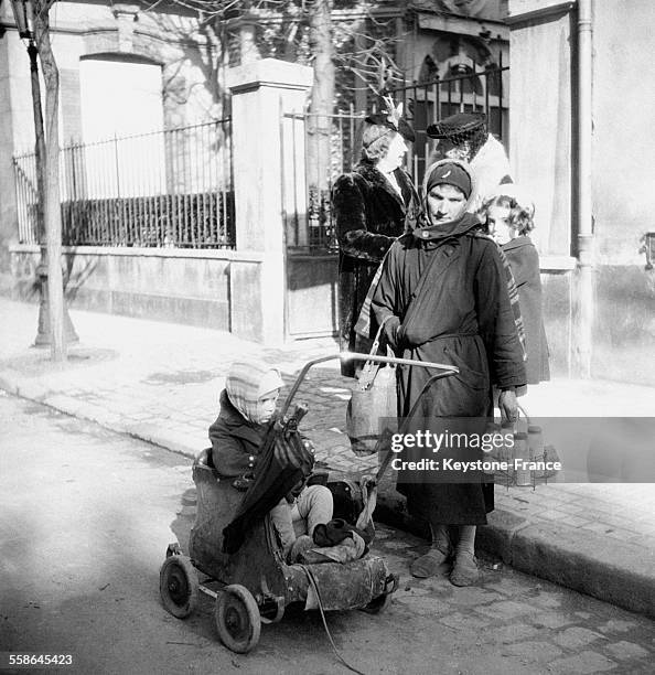 Femme et son enfant devant le dispensaire de la Croix-Rouge 'La goutte de lait', distribuant du lait pour les enfants en bas âge, à Vichy, France,...