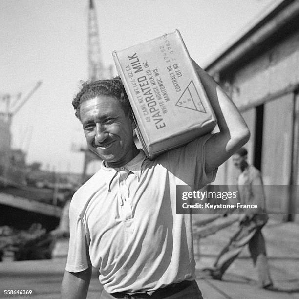 Un homme décharge les marchandises servant au ravitaillement des Français et apportées par le cargo français 'Mont Everest', circa 1940 en France.