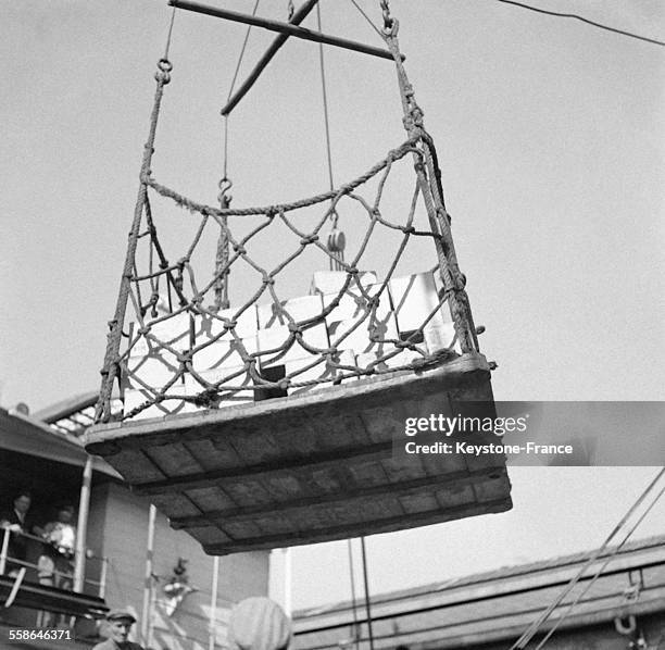 Les marchandises servant au ravitaillement des Français et apportées par le cargo français 'Mont Everest' sont déchargées par les marins, circa 1940...