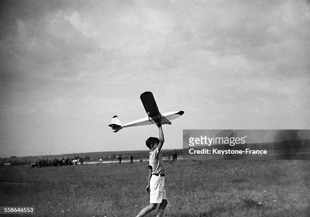 Un enfant joue avec un modèle réduit d'avion au meeting des modèles réduits, circa 1940.