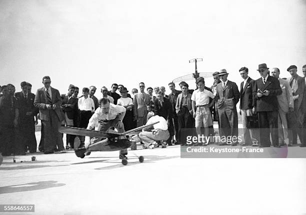 Des spectateurs assistent au décollage d'un modèle réduit d'avion au Meeting des modèles réduits, circa 1940.