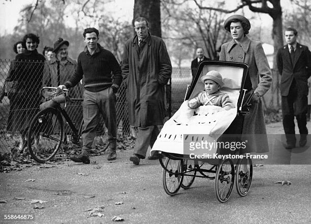 Le Prince Charles a Green Park, dans sa poussette, entoure de badaud qui le regarde, le 14 novembre 1950 a Londres, Royaume-Uni.