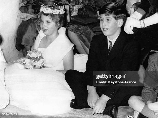 Princesse Anne en demoiselle d'honneur assise a cote de son frere le Prince Charles durant le mariage de Lady Pamela Mountbatten et de David Hicks a...