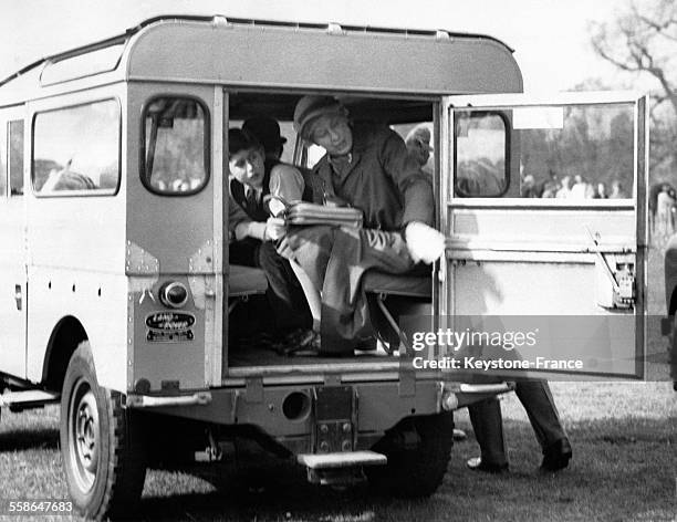 Le Prince Charles assis a cote de la Princesse Margaret se penche pour regarder quelque chose hors de la voiture apres avoir visite l'arene de...