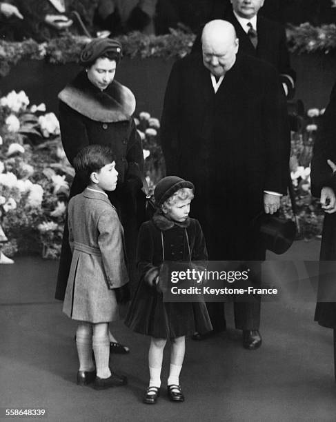 La Reine Elizabeth, son fils le Prince Charles et sa fille la Princesse Anne, et Sir Winston Churchill attendent la Reine Mere a la gare de Waterloo...