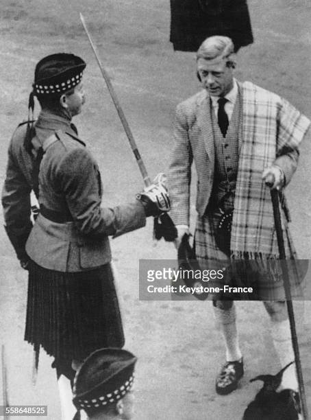 Le roi Edward VIII en costume traditionnel ecossais parle avec un garde le 18 septembre 1936, a Balmoral, Ecosse, Royaume-Uni.