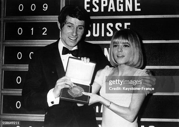 Udo Jurgens, chanteur autrichien vainqueur du Grand Prix de l'Eurovision, photographié avec France Gall qui lui remet la medaille, le 6 mars 1966 au...