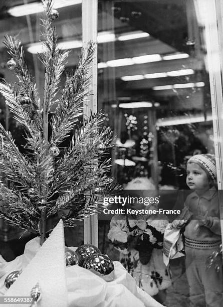 Enfants admirant un sapin dans une vitrine de Noel, a Moscou, Russie, le 1er decembre 1965.