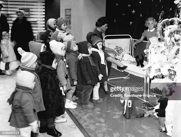 Groupe d'enfants admirant des jouets et un sapin dans un magasin quelques jours avant la fin de l'annee, a Bucarest, Roumanie.