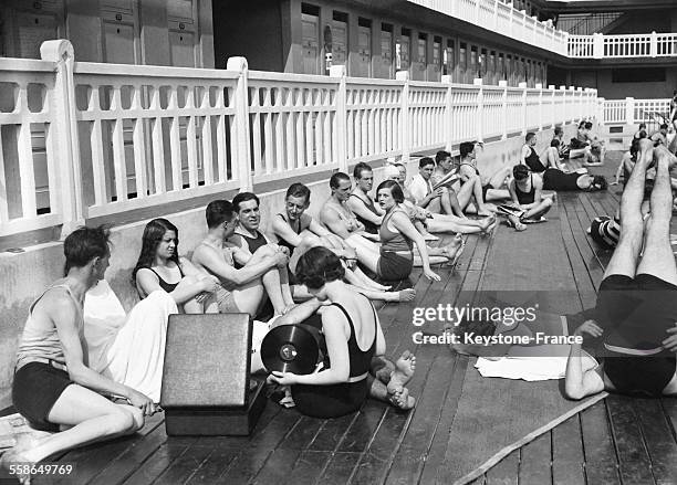 Parisiens venus se rafraîchir et écouter de la musique à la piscine Molitor, à Paris, France, circa 1930.