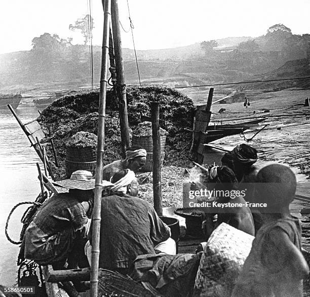 Marins prennant leur repas à bord d'une jonque transportant des allumettes, en Chine, circa 1910.